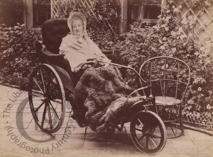 Elderly woman in a bath chair