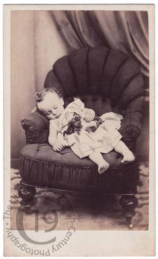 Bare-footed child on armchair